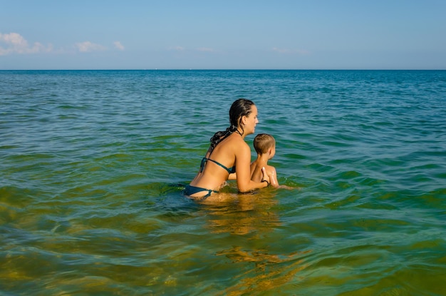 Una donna e un bambino nuotano nel mare.