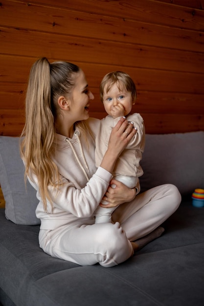 Una donna e un bambino sono seduti su un letto e la donna tiene in braccio il suo bambino.