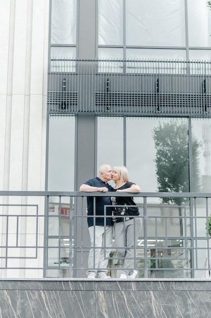 una donna e un uomo si abbracciano vicino a un edificio di vetro