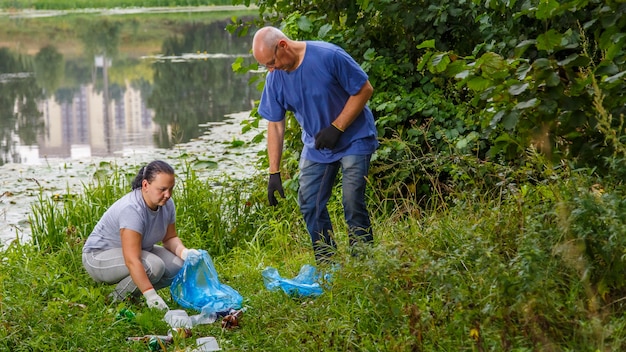 Una donna e un uomo volontari puliscono la spazzatura da una discarica nel parco.