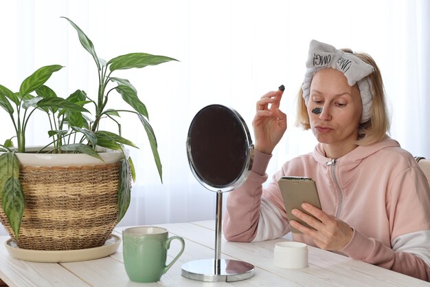 Una donna esegue procedure cosmetiche davanti a uno specchio