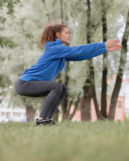 Una donna europea fa sport in un parco o in un luogo pubblico per riscaldarsi e fare jogging all'aria aperta