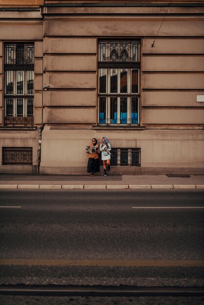 Una donna europea moderna e una donna musulmana con l'hijab camminano per le strade della città vestite con abiti del XIX secolo mentre portano in mano giornali, fiori e pane.