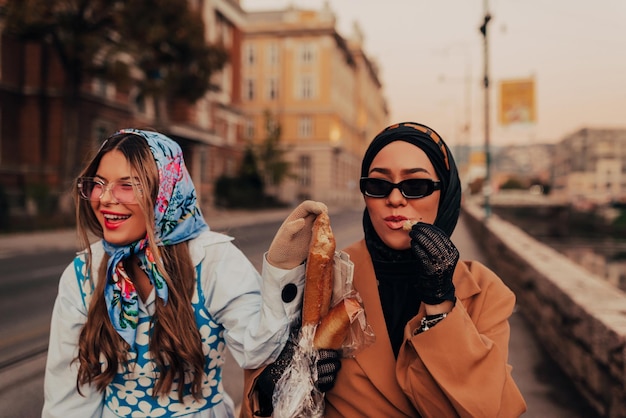 Una donna europea moderna e una donna musulmana con l'hijab camminano per le strade della città vestite con abiti del XIX secolo mentre portano in mano giornali, fiori e pane.