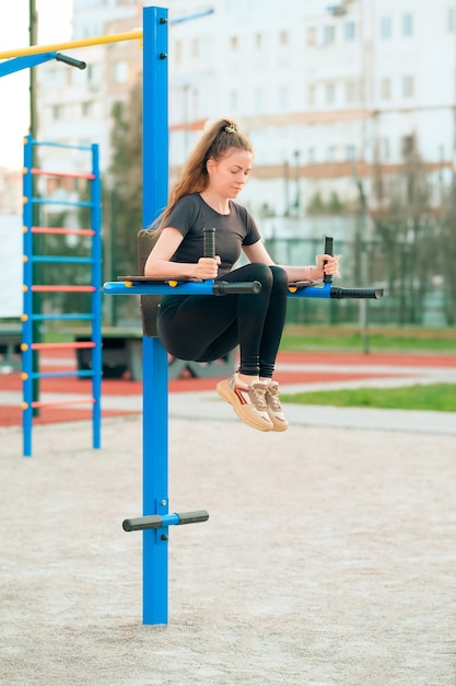 Una donna fa sport su un bar orizzontale all'aperto