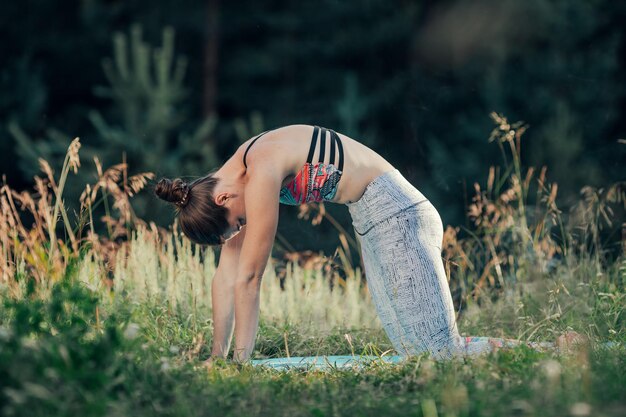 Una donna fa yoga all'aria aperta. Il concetto di sport.