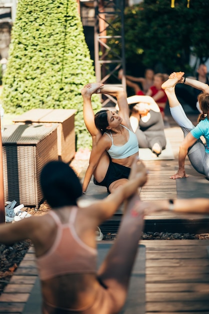 Una donna fa yoga insieme al suo gruppo all'aria aperta