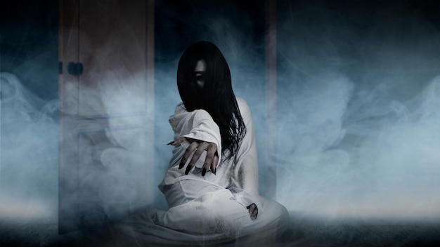 Una donna fantasma spaventosa striscia sul pavimento con sfondo bianco fumo Concetto di Halloween donna spaventosa