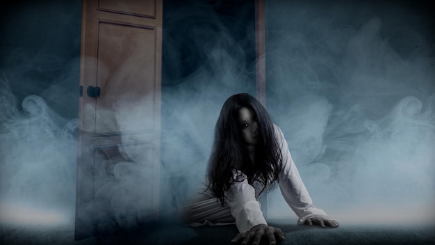 Una donna fantasma spaventosa striscia sul pavimento con sfondo bianco fumo Concetto di Halloween donna spaventosa