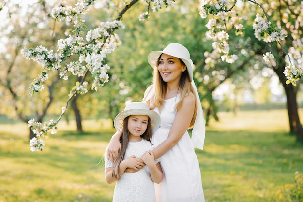 Una donna felice e sua figlia in un giardino primaverile in fiore Il concetto di festa della mamma