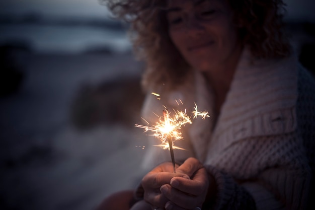 Una donna guarda la luce scintillante all'aperto e festeggia