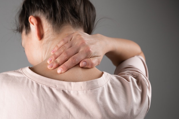 Una donna ha mal di collo dopo una dura giornata di lavoro.