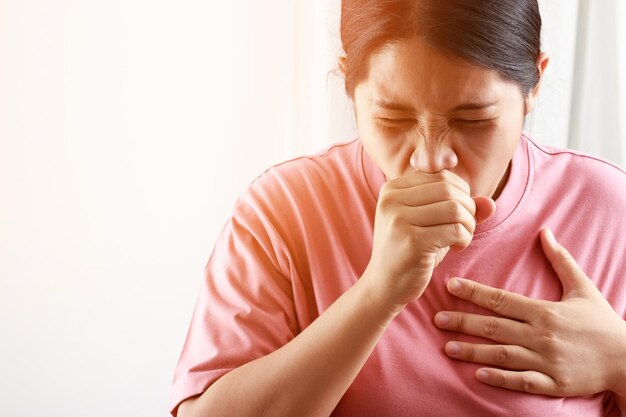 Una donna ha sintomi di tosse, espettorato, influenza causati dal COVID-19.