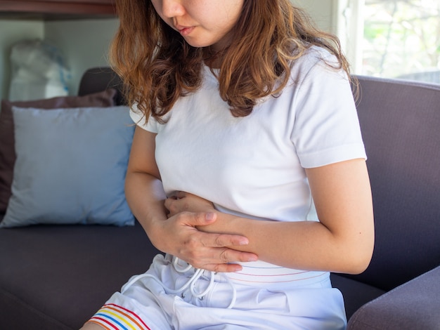 Una donna ha un forte mal di stomaco. Dolori mestruali