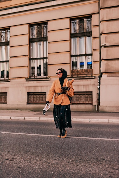 Una donna hijab che indossa un lussuoso abito vintage francese mentre cammina per le strade della città