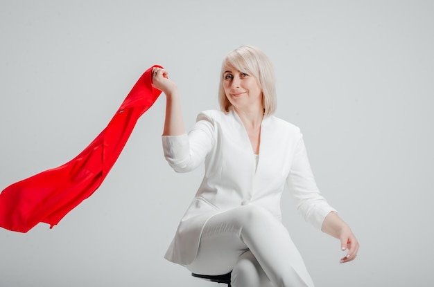 una donna in abito bianco con una sciarpa rossa su sfondo bianco