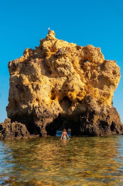 Una donna in acqua su un arco a Praia dos Arrifes Algarve beach Albufeira Portogallo