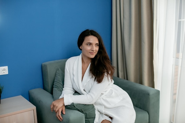 una donna in camice bianco in una stanza d'albergo