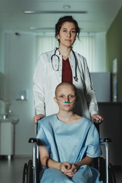 Una donna in camice da ospedale si trova in un letto d'ospedale con un medico in abito blu.