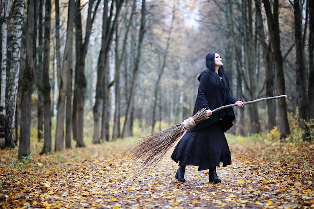 Una donna in costume da strega in una fitta foresta durante un rituale