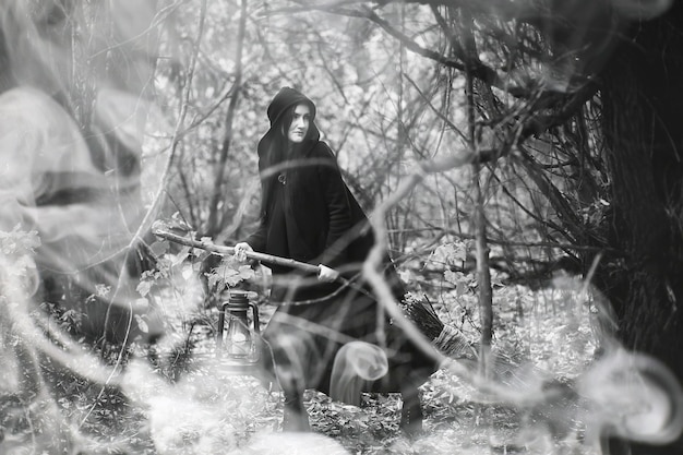 Una donna in costume da strega in una fitta foresta durante un rituale