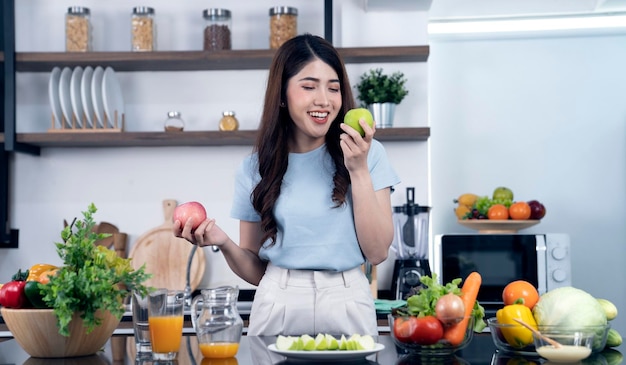 Una donna in cucina con un'insalata di frutta e verdura