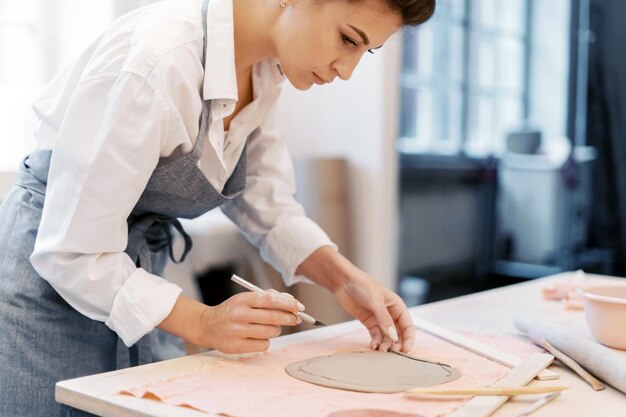 Una donna in grembiule lavora in un laboratorio di ceramica