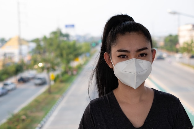 una donna in piedi che indossa una maschera respiratore N95