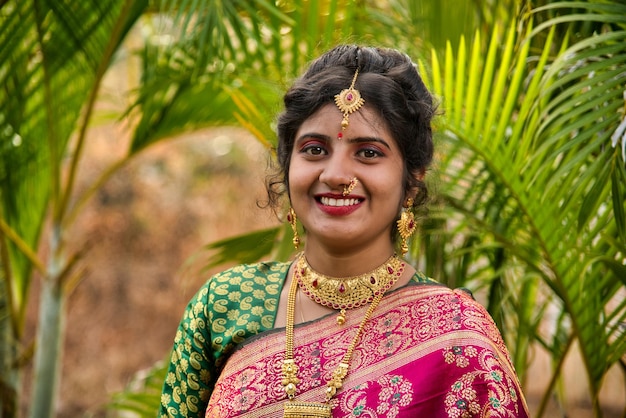 una donna in sari con un anello d'oro sulla testa