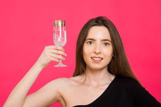 Una donna in studio con un bicchiere di champagne in attesa del Natale Capodanno 2023