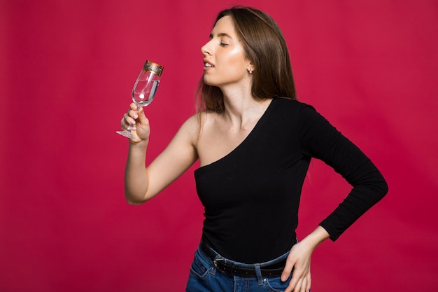 Una donna in studio con un bicchiere di champagne in attesa del Natale Capodanno 2023