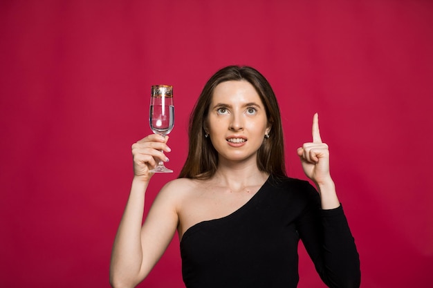 Una donna in studio con un bicchiere di champagne in attesa del Natale Capodanno 2023