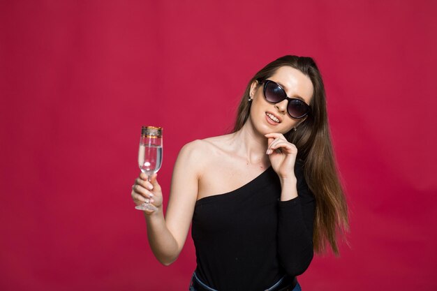 Una donna in studio con un bicchiere di champagne in attesa del Natale Capodanno 2023