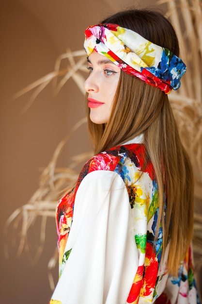 Una donna in un abito colorato con una sciarpa in testa