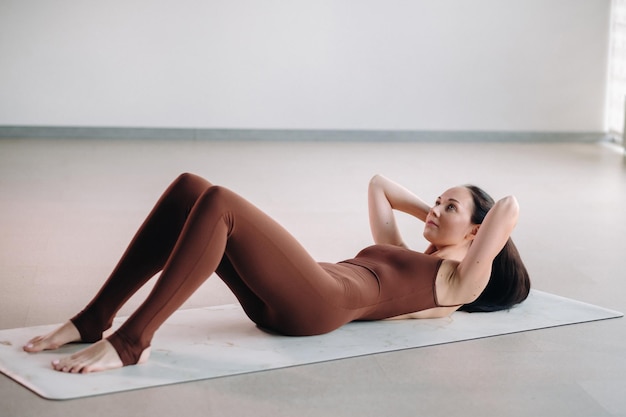 Una donna in un abito marrone fa yoga in una sala fitness Uno stile di vita sano fitness training selfcare