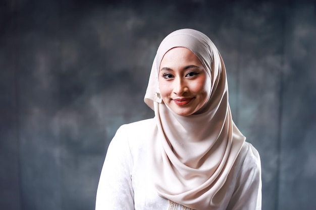 Una donna in un hijab bianco con uno sfondo scuro