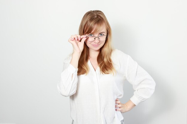 Una donna in una camicetta e occhiali su uno sfondo bianco ritratto di affari