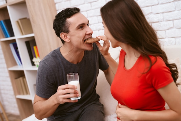 Una donna incinta e suo marito mangiano insieme i biscotti.