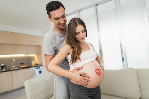 Una donna incinta in posa con suo marito.