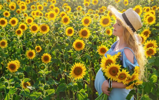 Una donna incinta in un campo di girasoli