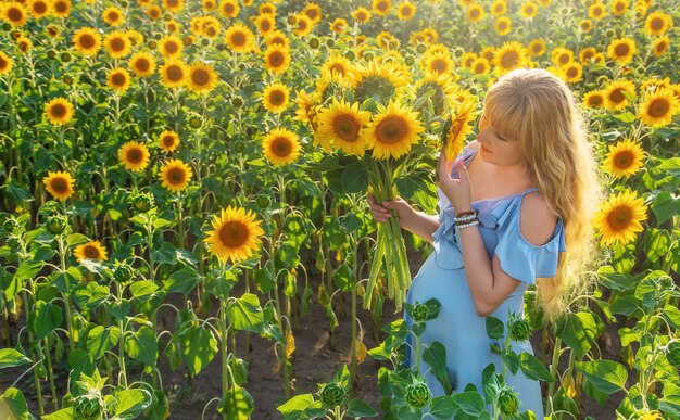 Una donna incinta in un campo di girasoli