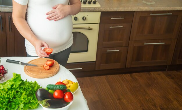 Una donna incinta mangia frutta e verdura