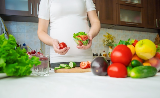 Una donna incinta mangia frutta e verdura