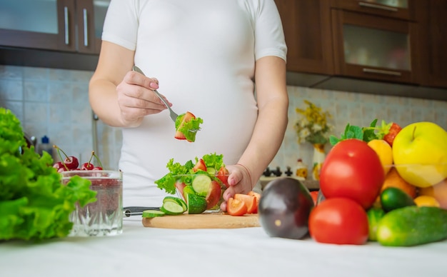 Una donna incinta mangia frutta e verdura