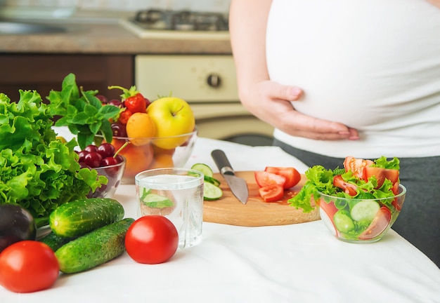 Una donna incinta mangia frutta e verdura