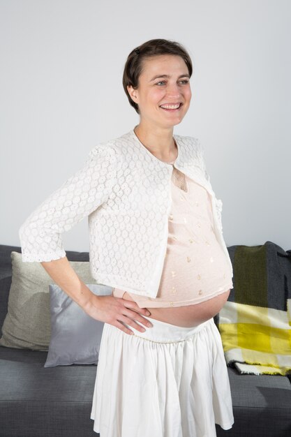 Una donna incinta su uno sfondo bianco