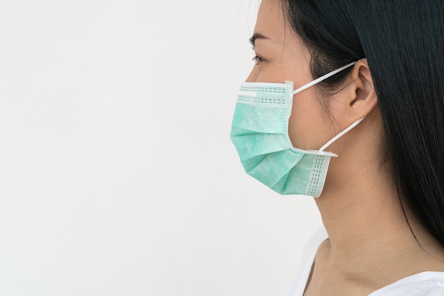 Una donna indossa una maschera che protegge dalla diffusione del Coronavirus