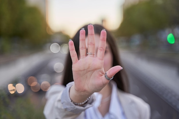 Una donna irriconoscibile che alza la mano è un segno di protesta per fermare la violenza o l'abuso
