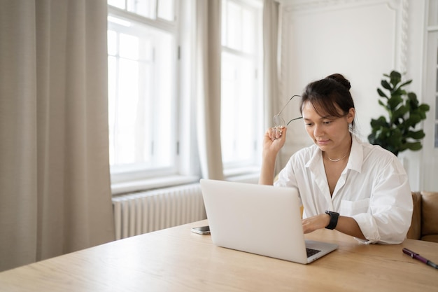 Una donna lavora a casa usa un laptop fa una relazione sul posto di lavoro online