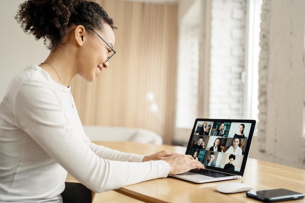 Una donna lavora in un ufficio online con i colleghi chat di videocomunicazione sul posto di lavoro